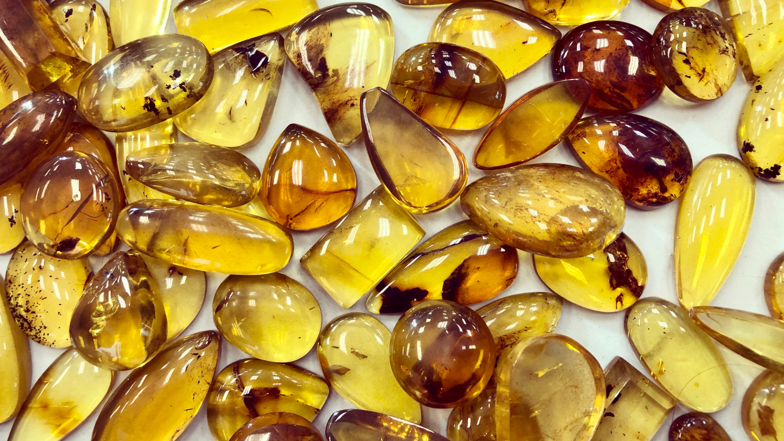 Full frame of smooth citrine gemstone cabachons on white background